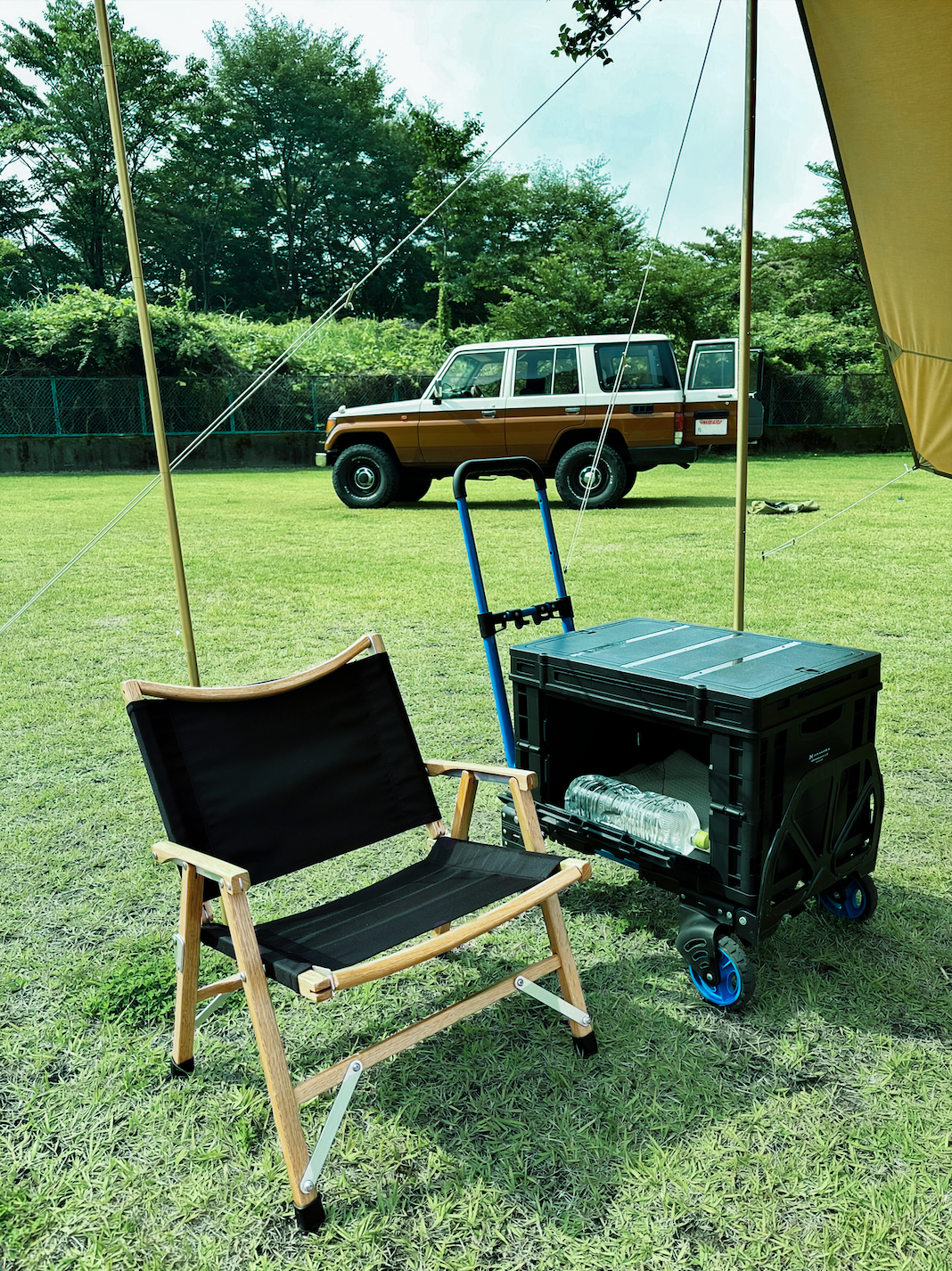 キャンプサイトでローチェアの横に置いたFLATCART 2x4（ブルー）とテーブルコンテナ